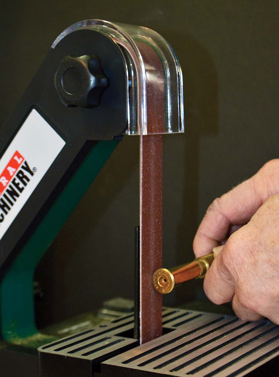Removing a few thousandths to bring rim diameter down to size, using a belt sander. Tread carefully, allow the sander to spin the case, and you’ll end up with a perfectly round, perfectly sized rim.